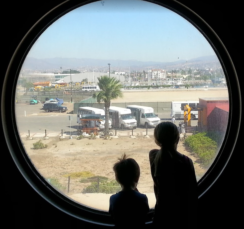 Kids looking out the cruise ship porthole in Ensenada.