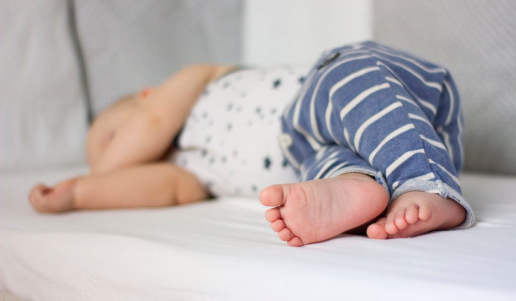 Cute sleeping baby boy in a bed.
