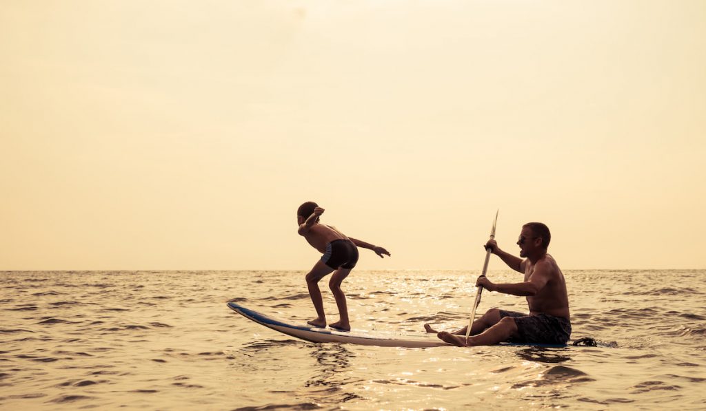 Father and son playing on the beach at the day time.
