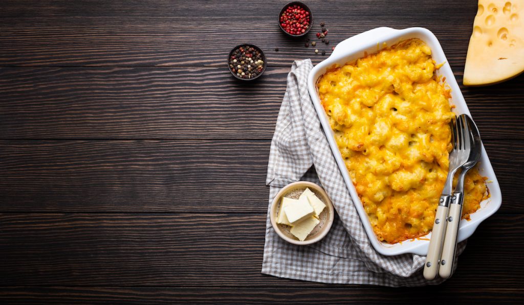 Macaroni and cheese in casserole on wooden table